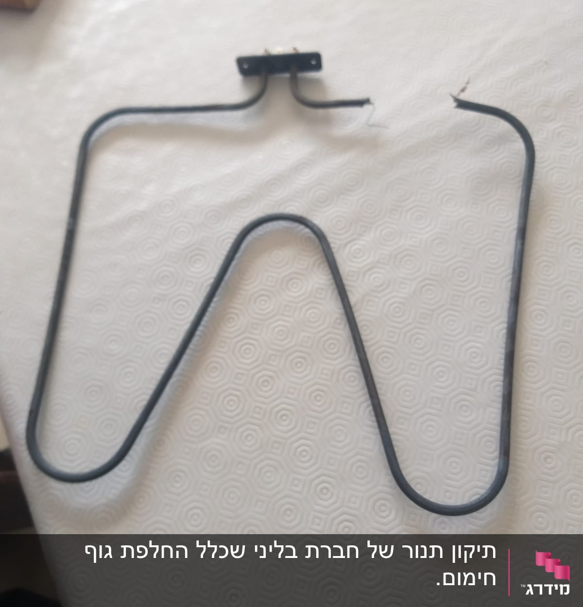 גוף חימום מתכתי בצורת W על שולחן לבן